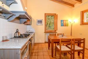 a kitchen with a table and chairs and a kitchen with a stove at Colleincanto Appartamento Vittorio in Gavardo