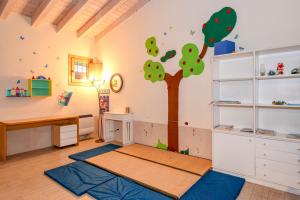 a room with a desk and a tree on the wall at Colleincanto Appartamento Vittorio in Gavardo