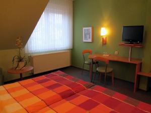 アインベックにあるGasthaus Winkelvoßのベッドルーム(ベッド1台、テーブル、テレビ付)