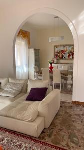 een woonkamer met een witte bank en een tafel bij Casa Gisella in Sannicola