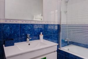 La salle de bains est pourvue d'un lavabo, d'un miroir et d'une baignoire. dans l'établissement Classico Guesthouse, à Vila Nova de Gaia