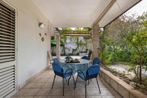 a patio with a blue table and chairs on it at El Buen Retiro by BarbarHouse in Baia Verde