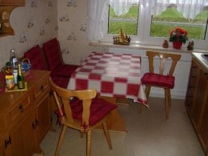 a kitchen with a table and two chairs and a table at Ferienwohnung-Kuestensnack in Cuxhaven