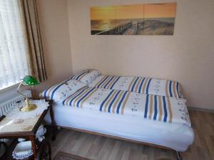 a bedroom with two beds and a table with a lamp at Ferienwohnung-Kuestensnack in Cuxhaven