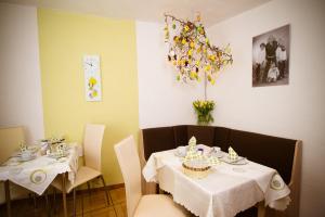 uma sala de jantar com duas mesas com toalha de mesa branca em Pension Haus Andreas em Cochem