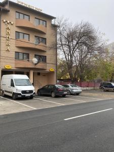 un estacionamiento con coches estacionados frente a un hotel en Pensiunea Andra en Timisoara