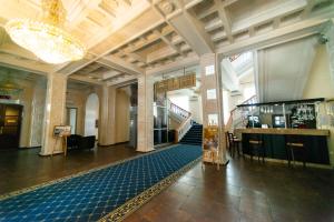 a lobby with a staircase in a building with a chandelier at Sevastopol Hotel in Sevastopol