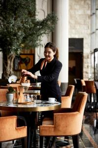 a woman sitting at a table in a restaurant at Four Seasons Hotel Bahrain Bay in Manama