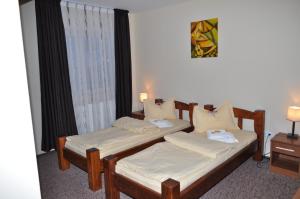 two twin beds in a room with a window at Becsi Szelet in Miercurea-Ciuc +12 photos