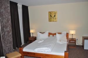 a bedroom with a bed with white sheets and pillows at Becsi Szelet in Miercurea-Ciuc