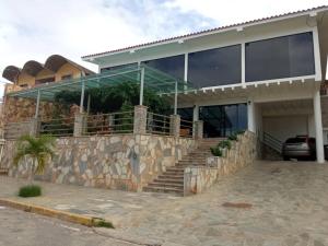 una casa grande con una pared de piedra y escaleras delante en Posada Villa del Carmen, en Catia La Mar