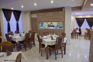 a restaurant with white tables and chairs and a large window at Becsi Szelet in Miercurea-Ciuc