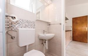 Un baño blanco con lavabo e inodoro. en Apartments Lord Pirovac, en Pirovac 82 fotos más