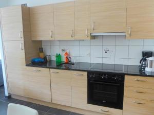 a kitchen with wooden cabinets and a black oven at Apartment Andromède 3-pièces A34 by Interhome in Moleson
