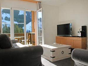 a living room with a couch and a tv at Apartment Andromède 3-pièces A34 by Interhome in Moleson