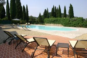 a patio area with chairs, tables and a pool at Hotel Villa Dei Bosconi in Fiesole