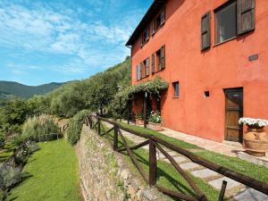 a red building with a fence next to it at Apartment La Sorgente - BUT150 by Interhome in Buti