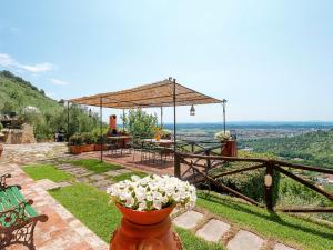a patio with a table and chairs and flowers at Apartment La Sorgente - BUT150 by Interhome in Buti