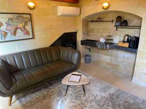 a living room with a leather couch and a table at Lulu Boutique Hotel in Żebbuġ