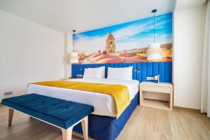 a room with a bed, a desk, and a painting on the wall at Eurostars Astoria in Málaga