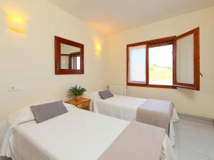 2 camas en una habitación con espejo y ventana en Holiday Home Mas Rovira 8 by Interhome, en Bellcaire dʼEmpordà