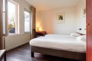 um quarto de hotel com uma cama e uma janela em Het Wapen van Leiden em Appingedam