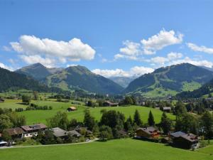 een groen veld met bergen op de achtergrond bij Apartment Meielblick by Interhome in Gstaad