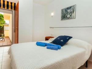 a bedroom with a white bed with blue pillows on it at Holiday Home Wouters by Interhome in El Puerto