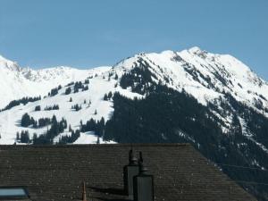 una montaña cubierta de nieve con una casa delante en Apartment Chez-Nous by Interhome, en Gstaad