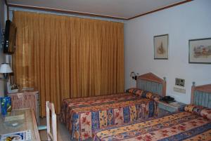 Habitación de hotel con 2 camas y ventana en Hotel Azahar en Murcia