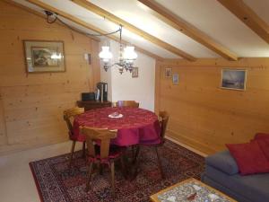 uma sala de jantar com uma mesa e um sofá em Apartment Steimandli by Interhome em Gstaad