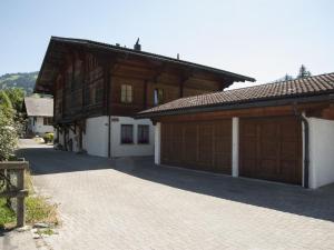 ein Haus mit zwei Garagentüren und einer Einfahrt in der Unterkunft Apartment Steimandli by Interhome in Gstaad