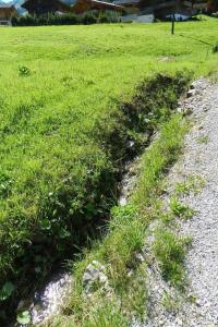 a patch of grass on the side of a road at Apartment Majelas Heiti by Interhome in Gsteig