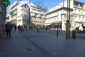 a group of people walking down a street with buildings at Labarta in Vigo