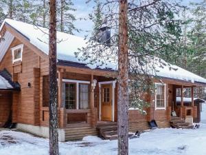 レヴィにあるHoliday Home Aslakit a by Interhomeの雪の中の木々の丸太小屋