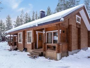 レヴィにあるHoliday Home Aslakit b by Interhomeの屋根に雪が積もった木造キャビン