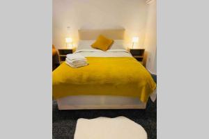 a bedroom with a bed with a yellow blanket at Swansea house in Birmingham
