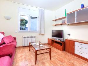 a living room with a couch and a tv at Holiday Home Eva by Interhome in L'Escala