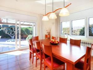 a dining room with a wooden table and chairs at Holiday Home Eva by Interhome in L'Escala