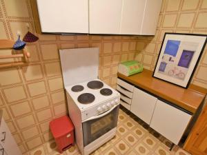 miniaturowa kuchnia z kuchenką i zdjęciem w obiekcie Apartment Val di Fassa by Interhome w mieście Alba di Canazei