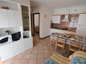 una cucina e una sala da pranzo con tavolo e sedie di Apartment Mediterraneo-4 by Interhome a Rosapineta