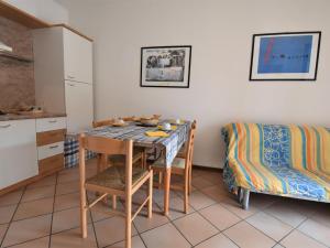 una cucina con tavolo, sedie e divano di Apartment Mediterraneo-4 by Interhome a Rosapineta