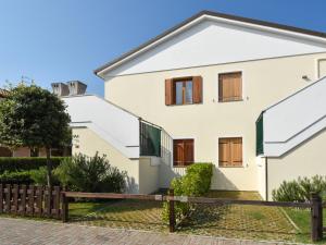 a white house with a wooden fence at Apartment Mediterraneo-3 by Interhome in Rosapineta