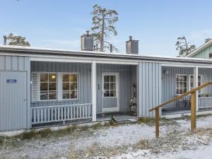 ein graues Haus mit einer Veranda und einer Tür in der Unterkunft Holiday Home Saariselän väärtin kammi 2 by Interhome in Saariselkä