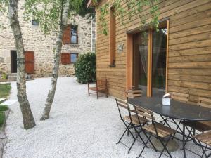 a patio with a table and chairs next to a building at Ecogîte Les Papillons des Sucs in Saint-Maurice-de-Lignon