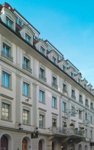 ein großes weißes Gebäude mit Fenstern und Balkonen in der Unterkunft Hotel Weißes Kreuz in Bregenz