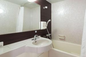 a bathroom with a sink and a mirror at Comfort Hotel Hiroshima Otemachi in Hiroshima
