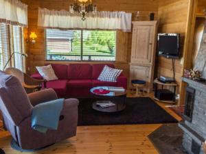 ein Wohnzimmer mit einem roten Sofa und einem Kamin in der Unterkunft Holiday Home Villa tahko by Interhome in Tahkovuori