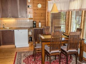 eine Küche mit einem Esstisch und Stühlen in der Unterkunft Holiday Home Villa tahko by Interhome in Tahkovuori