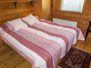 ein Schlafzimmer mit einem Bett mit einer gestreiften Decke in der Unterkunft Holiday Home Villa tahko by Interhome in Tahkovuori